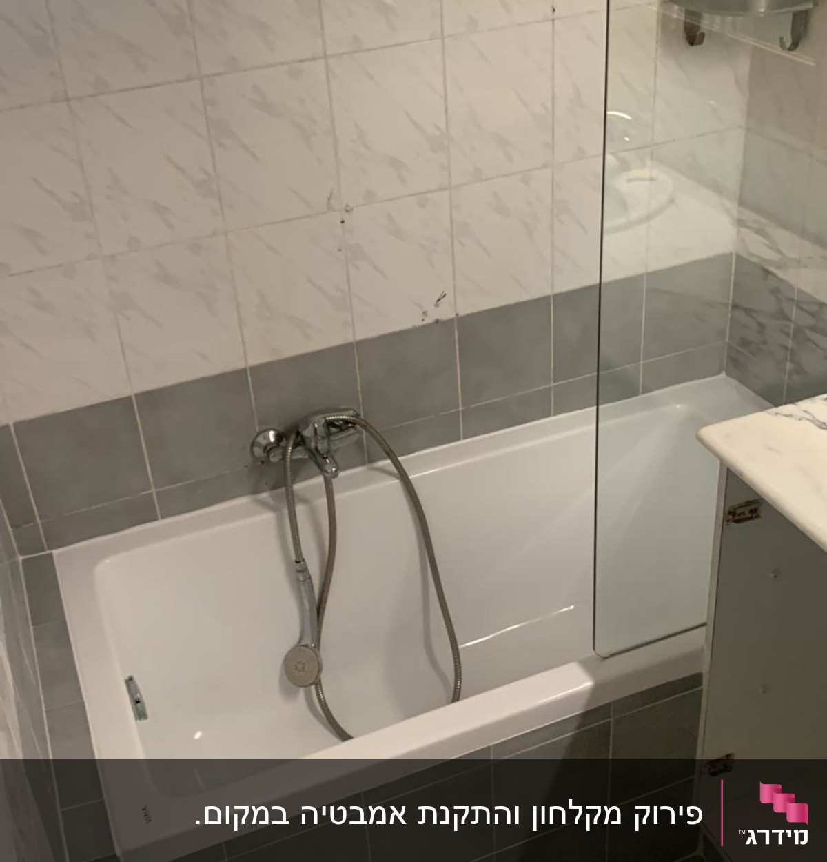 אמבטיה עם אריחים אפורים ולבנים, ברז ומקלחת